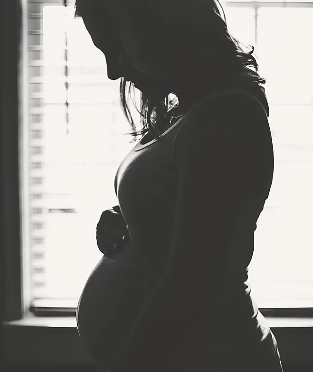 Mujer embarazada pensando en su bebé.
